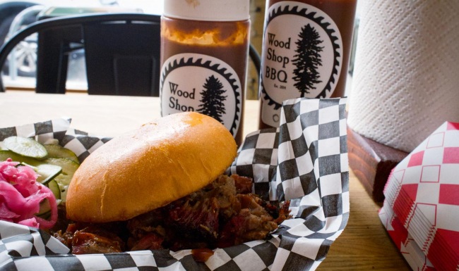 a sandwich and a bottle of bbq sauce